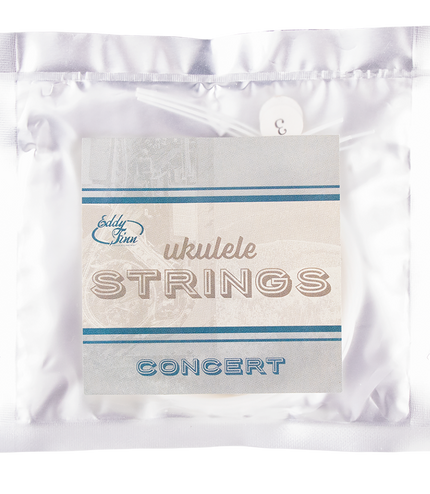 A clear package of concert ukulele strings with silver backing